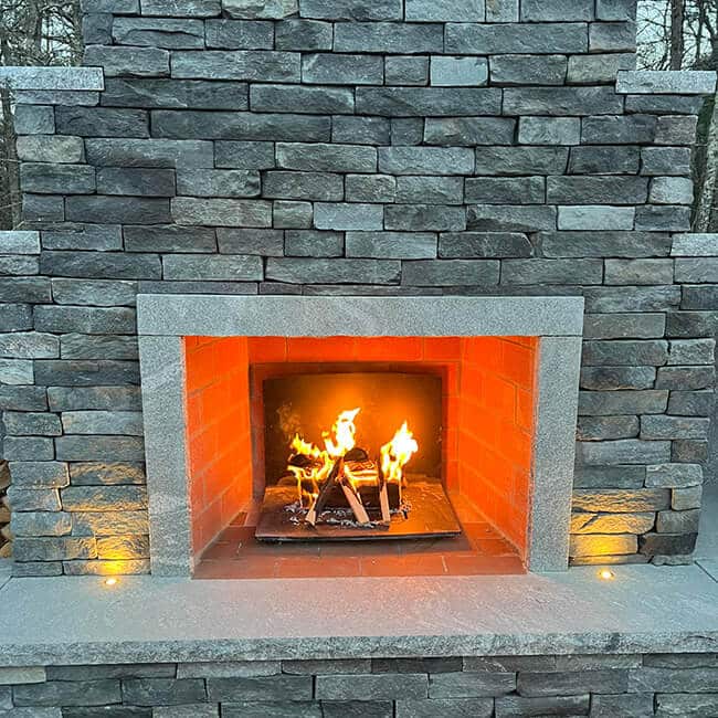 Outdoor fireplace in a home in Wareham MA by Brian DeMedeiros BD Masonry.